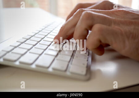 Männliche Hände schreiben auf dem Computer Stockfoto