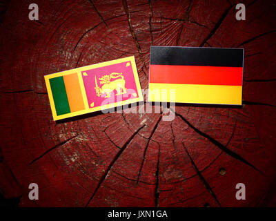 Sri Lanka Fahne mit deutscher Flagge auf einem Baumstumpf isoliert Stockfoto
