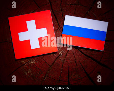Schweizer Flagge mit russischen Flagge auf einem Baumstumpf isoliert Stockfoto