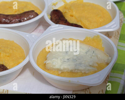 Polenta mit Gorgonzola und gegrillte Würstchen, typische Gerichte der italienischen Küche, serviert in einem Barbecue in Vigezzo Tal, Norditalien Stockfoto