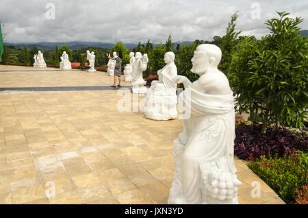 Wat Huai Pla Kung 9 Stufe Tempel, Frau nimmt selfie mit Ihrem Telefon durch weiße Statuen unter gigantischen chinesischen Stil Buddha Statue, Chiang Rai Thailand Stockfoto