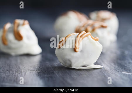 Weiße Schokolade Trüffel für Weihnachten oder Valentines Tag beträufelt mit Erdnussbutter Sauce. Extrem flache Tiefenschärfe mit selektiven Fokus auf c Stockfoto