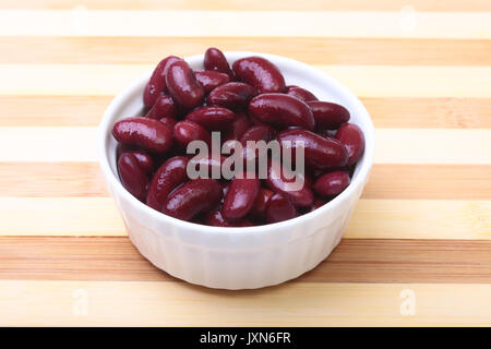Heap in der Dose rote Bohnen in der Soße in weiße Schüssel. vegetarisches Essen. Phaseolus vulgaris. Stockfoto