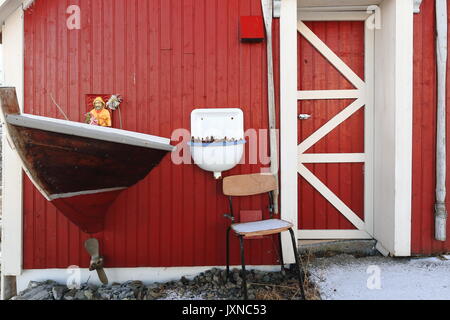 Exzentrisch verzierten - Rot bemalte Fassade des Rorbu-traditionelle saisonale Fischerhütte jetzt für touristische Nutzung neben dem Europäischen E10 Straße gerade weg. Stockfoto