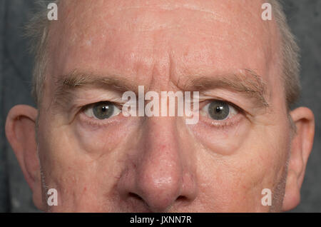 Eine enge, direkte Stare aus den Augen eines älteren Mannes Stockfoto