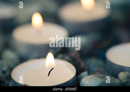 Tee - Kerzen auf Kies Steine selektiven Fokus Nahaufnahme Stockfoto