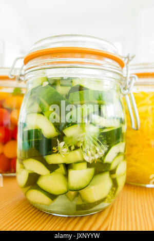 Lacto-fermentierten Gemüse. Glas Gläser auf hölzernen Küchentisch mit hellen Hintergrund. Tomaten, Zucchini (Zucchini) und Gurke fermentiert. Stockfoto