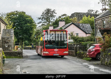 Ein Mann, der die Zahl 46 Bus in Okehampton, entlang der Hauptstraße des Dorfes, in der Nähe von Okehampton Lydford, Devon, England, UK. Stockfoto