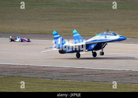 Schukowski, Moskau, Russland - 28. August 2015: Mikoyan Gurevich MiG-29 UB1 weiß der russischen Luftwaffe Aqua-lounge Rennen mit Formel 3 Auto in Schukow Stockfoto