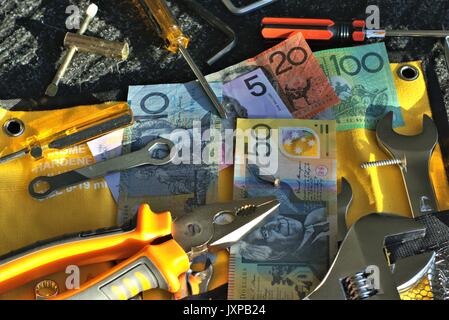 Australische Geld und Werkzeuge der Mechaniker auf schwarz-Matte in direktem Sonnenlicht Stockfoto