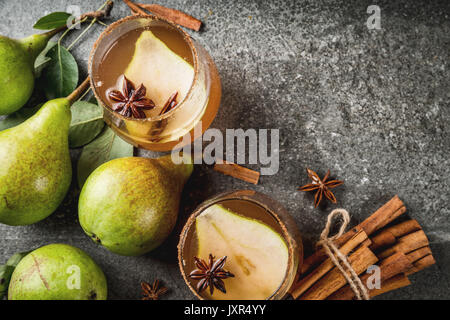 Herbst Getränke. Glühwein. Traditionelle Herbst würzigen Cocktail mit Birne, Apfelwein und Schokolade Sirup, mit Zimt, Anis, braunen Zucker. Auf schwarzen Stein Stockfoto