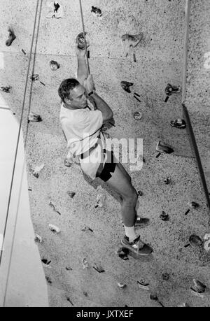 Michael Rubens Bloomberg, candid Shot, Bloomberg, Klettern an der Kletterwand und Dangling aus dem Gurt, 47 Jahre alt, 1997 Ca. Stockfoto