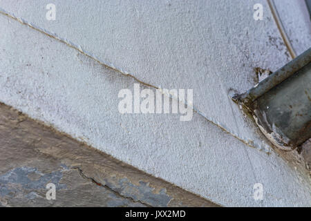 Kleine Risse im Putz an der Außenwand des durch eine strukturelle Schäden verursacht hat. Stockfoto