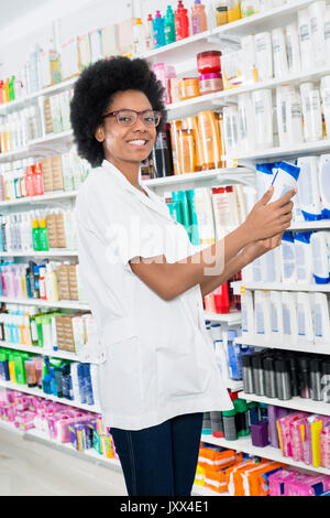 Weibliche Chemiker Holding Shampoo Flasche in der Pharmazie Stockfoto