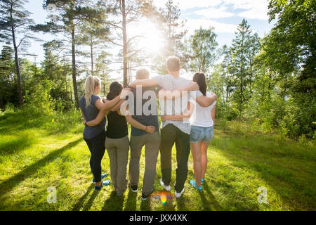 Ansicht der Rückseite des multiethnischen Mitarbeiter ständigen Arme um In Fores Stockfoto