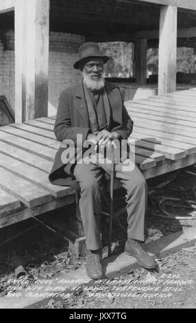 Ambrose Hillard Douglas, ein afroamerikanischer Bürgerkrieg Sklave, sitzt draußen und hält einen Stock auf der Lewis Plantage und Terpentin still, 1940. Stockfoto