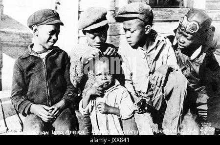 Vier jungen afrikanischen amerikanischen Jungen draussen sitzen und an der Spitze eines jungen afrikanischen American Girl Kopf als einer der Junge spielt mit ihren Haaren, auf der Lewis Plantage in Brooksville, Florida, 1940. Stockfoto