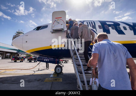 Die Fluggäste einen Ryanair Flug über die vorderen Stufen am Flughafen Reina Sofia, Teneriffa, Kanarische Inseln, Spanien Stockfoto