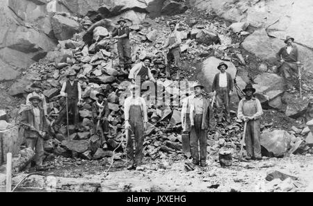 Afrikanischen amerikanischen und weißen Bergarbeiter sind auf einem Hügel von großen Felsen, sie sind alle posieren für das Bild, 1920. Stockfoto