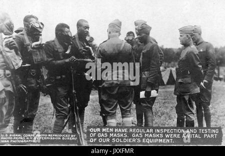 US-Signal-Korps des Ersten Weltkriegs, das regelmäßig Gasmasken inspiziert und getestet hat; afroamerikanische Soldaten, die um höhere Offiziere mit Gasmasken stehen, 1917. Stockfoto