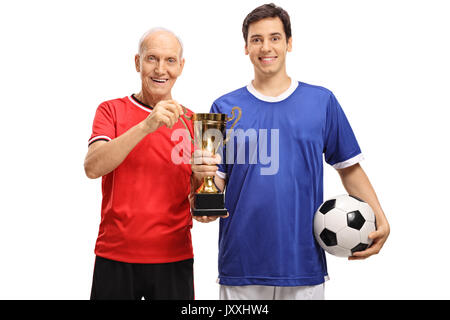 Junge Fußballspieler und ein älterer Spieler, der eine goldene Trophäe auf weißem Hintergrund Stockfoto