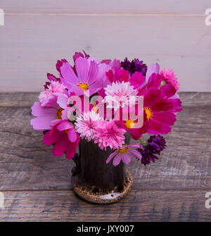 Ein Bouquet von rosa und lila Blumen cosmea oder Cosmos mit Band auf rustikalen hölzernen Brettern. Kopieren Sie Platz. Mutter, Valentines, Frauen, Hochzeit Konzept Stockfoto