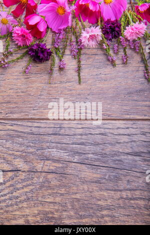 Ein Bouquet von rosa und lila Blumen cosmea oder Cosmos mit Band auf rustikalen hölzernen Brettern. Kopieren Sie Platz. Mutter, Valentines, Frauen, Hochzeit Konzept Stockfoto