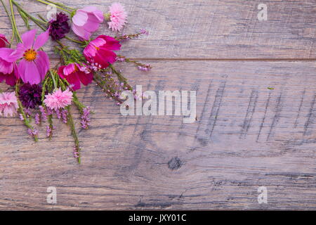 Ein Bouquet von rosa und lila Blumen cosmea oder Cosmos mit Band auf rustikalen hölzernen Brettern. Kopieren Sie Platz. Mutter, Valentines, Frauen, Hochzeit Konzept Stockfoto