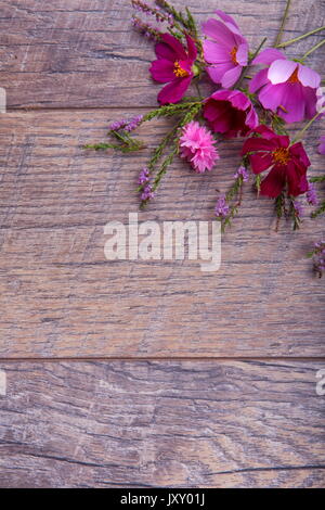 Ein Bouquet von rosa und lila Blumen cosmea oder Cosmos mit Band auf rustikalen hölzernen Brettern. Kopieren Sie Platz. Mutter, Valentines, Frauen, Hochzeit Konzept Stockfoto
