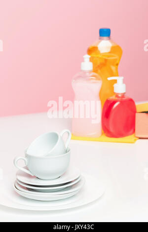 Mehrere Platten, eine Küche Schwämme und Plastikflaschen mit natürlichen Geschirrspülmittel Seife in der Hand spülen. Stockfoto