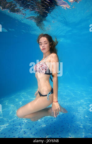 Schöne junge Frau im Bikini posieren unter Wasser im Pool Stockfoto
