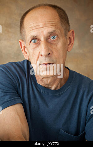 Besorgt reifer Mann im Studio sitzen Stockfoto