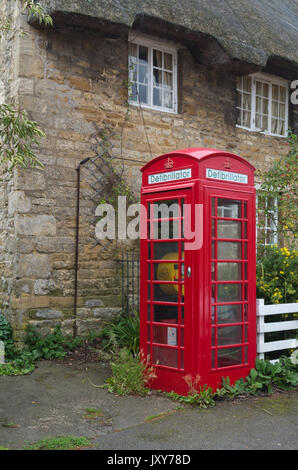 Alten roten Telefon Kiosk im Dorf Geddington, nun als ein Defibrillator, Teil der BT einen Kiosk System verwendet. Stockfoto