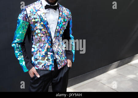 Mid section of man in sequinned prismatic jacket and bow tie Stockfoto