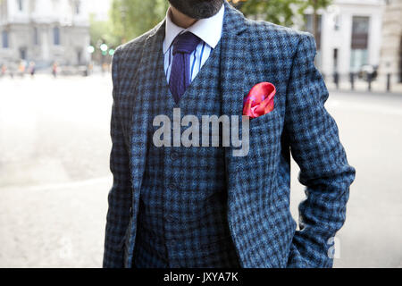 Mann in Blau prüfen Weste und Jacke mit gestreiftem Hemd und Krawatte Stockfoto