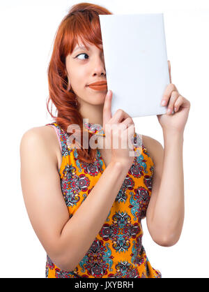 Frau spielt mit dem Papier, die einen Teil des Gesichts. Rothaarige Mädchen tragen gelbe und bunten Kleid. Floralen Muster. Mode und Stil. Sommer Stockfoto