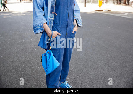 Frau in Jeans Jacke und Overall mit blauen Schuhe Stockfoto