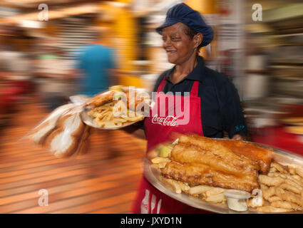 Kellnerin mit Platten von Fisch und Chips in Kalky's Restaurant in Kalk Bay, Kapstadt. Stockfoto