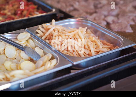 Pommes Frites und Kartoffelchips auf einem Fast Food Stand Stockfoto