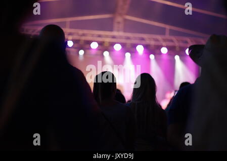 Hintergrundbeleuchtung Menschen mit Lila bei Konzert Stockfoto