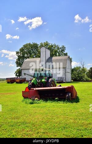 Veteran der Schlepper und die Ausrüstung vor einem ehrwürdigen Scheune auf einem Bauernhof im Nordosten von Illinois. Stockfoto