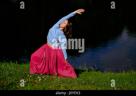 Sportlich fit kaukasischen Frau Asana Virabhadrasana 2 Krieger Pose Haltung in der Natur zu tun. Stockfoto