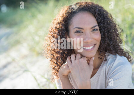 Portrait von lächelnden gemischten Rasse Frau am Strand Stockfoto