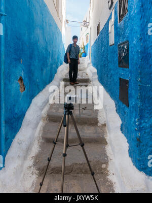 Udayas, Rabat, Marokko - Mai 06, 2017: Asiatische Tourist, der ein Foto von sich selbst mit Stativ, in einer schmalen Gasse in der Kasbah von Udayas, Rabat, Morocc Stockfoto