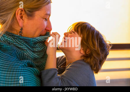 Weißen Mutter aufpassen Sohn spielen mit ihrem Kragen Stockfoto