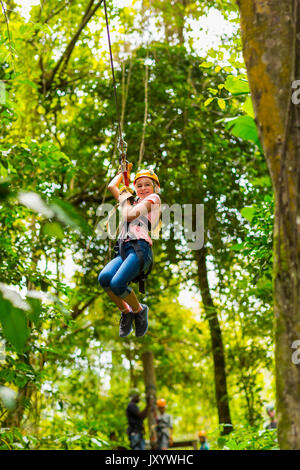 Kaukasische Mädchen hängen auf Zip Line in Wald Stockfoto