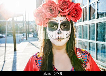 Hispanic Frau auf dem Bürgersteig tragen Schädel Gesicht Farbe Stockfoto