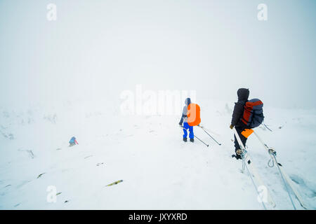 Kaukasische Wanderer Skier tragen auf dem Berg Stockfoto