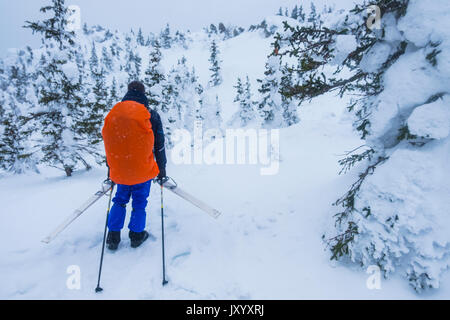 Kaukasische Wanderer Skier tragen auf dem Berg Stockfoto