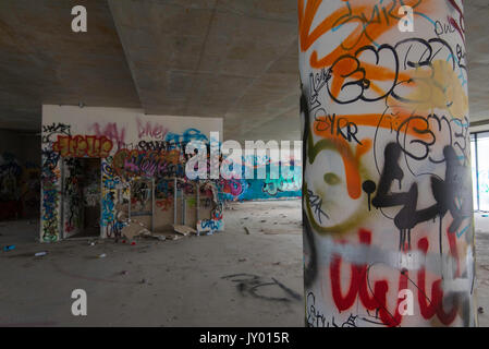 Sprühen Sie in einem verlassenen Geschäftsgebäude in Sydney, Australien, bemalte und mit Graffiti gekennzeichnete Wände und Aerosoldosen Stockfoto